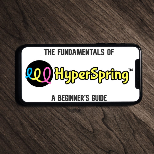Smart phone lying on table, showing "The Fundamentals of HyperSpring: A Beginner&