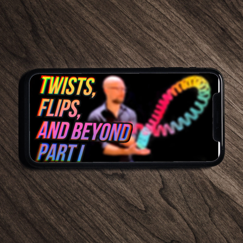 A smartphone sits on a table, displaying the cover for the Twists, Flips, and Beyond Part 1 video course.